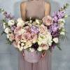 This elegant floral arrangement features a soft palette of blush pink roses