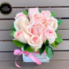 Blush pink roses with water droplets in a white wooden box tied with a pink ribbon