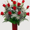 A luxurious arrangement of fresh red roses accented with greenery and soft