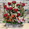 Red roses and pink lilies arranged in a wooden box