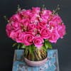 This arrangement includes 25-30 roses in glass vase with partial textured foil
