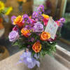 Shades of purple and orange roses and other blooms in a ginger