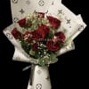 Hand wrapped bouquet made with 12 Red Roses surrounding foliage and luxury