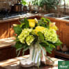 Moss' Spring Shower Bouquet is artistically arranged in a charming tan and
