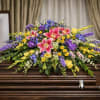 A casket adorned with beautiful flowers and greenery, a peaceful and elegant