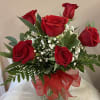 Six classic red roses accented with filler and greens, beautifully arranged with
