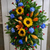 Bright and beautiful statement fresh spray of sunflowers, blue carnations, orange lily