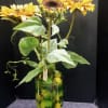 A beautiful arrangement featuring silk sunflowers in an oversized glass chalice filled