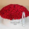 A very large, luxurious arrangement of vibrant red roses, densely arranged into