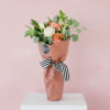 Seasonal blooms and foliage packaged in a couture pink market paper. Includes