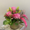 Medium pink roses, spray roses and asiatic lilies in a beautiful gold