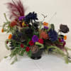 Give a creepy. crawly, spooky arrangements mad with mums, carnations, roses, marigolds
