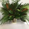 Magnolia branches among winter greenery in a gld vase