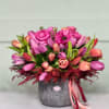 Gorgeous tulips and enchanting Ranunculuses arranged in a charming ceramic vase, inspiring
