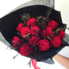 Romantically wrapped red roses with dark burgundy accents in black paper packaging.