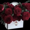 A beautiful square, wallet-shaped box filled with red roses and adorned with