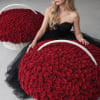 Woman in a black dress posed with two large baskets of red roses