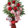 This romantic Valentines Day arrangement features rich red roses artfully layered 
