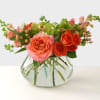 A lively pop of orange crush roses and cymbidium orchid greens, this