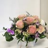 This enchanting arrangement features a soft, plush teddy bear nestled among a