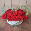  Red roses are designed in a white pottery container and accented