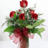 6 artfully arranged red rose in a glass vase with seasonal filler.