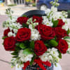 Velvety scarlet roses paired with delicate white blooms, artfully arranged in an