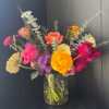 Seasonal, colorful flowers and foliage artfully arranged in a clear glass vase.

Year