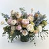 Large pastel bouquet in a dark glass vase