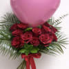 One dozen red roses with greenery and a heart shaped balloon (color