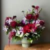 A lush, garden-style arrangement in deep burgundy, crimson, and lavender blooms--Moody and