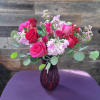 A lush blend of hot pink and red roses with soft blush