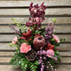 Cymbidium orchid, stem, protea , carnations, filler and greens arranged in a
