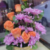 it is made with:
7 orange/high magic  roses
lavender/purple daisies/pompom