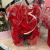 A charming bear crafted from red artificial roses, a sweet keepsake that