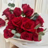 An abundant arrangement of red roses, chosen and placed as an offering