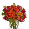 Arrangement includes orange roses, assorted red, purple/orange flowers and greenery in a