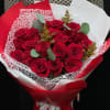 Bouquet of red roses wrapped in red and white paper