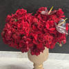 A lush , statement arrangement overflowing with velvety red roses accented with