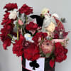 A whimsical mix of vibrant red flowers, delicate white accents, and charming