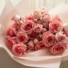 A romantic arrangement of pink roses and delicate spray roses, designed in