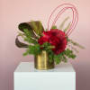 Red roses anchor this arrangement, surrounded by flowing lines and fresh green