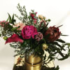 mix of hot pink and fuchsia florals in a gold cylinder vase