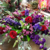 Red roses compliment purple stock, purple larkspur, burgundy snapdragons and purple alstroemeria