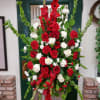 Standing spray on an easel with red gladiolus, bells of Ireland, red