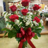 Six beautiful long stem red roses in a vase with greenery and