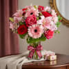 A charming mix of soft pink blooms and romantic red roses, artfully