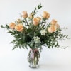 A dozen peach roses in vase.