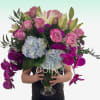 Featuring deep purple orchids, soft blue hydrangeas, and heirloom roses