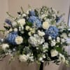1/2 casket cover with blue and white flowers. Flowers include:hydrangeas, roses, stock